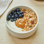 Bowl di yogurt con granola, burro di arachidi e mirtilli