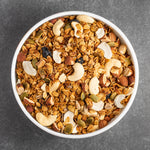 Ciotola con frutta secca e cereali su sfondo grigio
