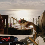 Persona tiene piatto con colazione vista mare