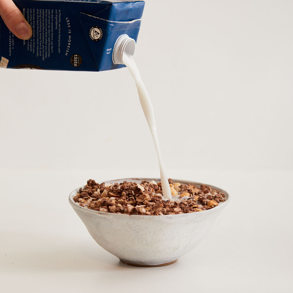 Bowl con chocolate lover granola e latte versato