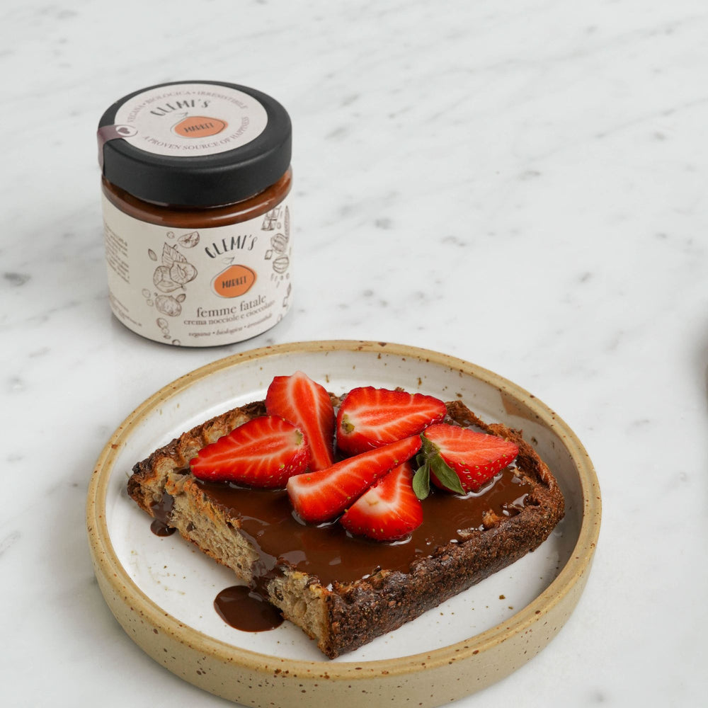 Crema spalmabile femme fatale su pane con fragole, su piatto bianco 
