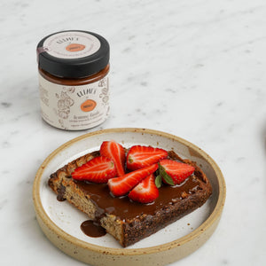 Crema spalmabile femme fatale su pane con fragole, su piatto bianco 