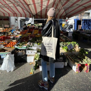 tote bag indossata da una ragazza al mercato e con su scritto if you're looking for a sing this is it